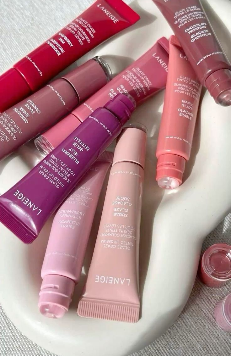 Pink lip gloss and beauty products aesthetic flatlay